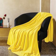 a black chair with a yellow blanket on it