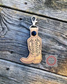 a cowboy boot shaped keychain on top of a wooden table