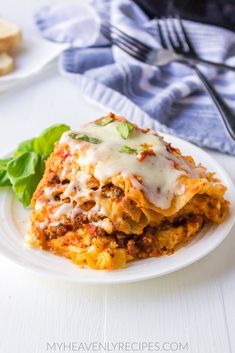 a white plate topped with lasagna covered in cheese