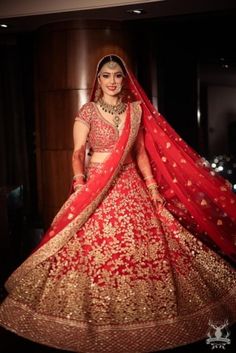 a woman in a red and gold bridal gown