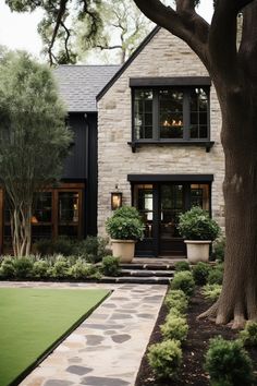 a house that has some trees in front of it and grass on the ground next to it