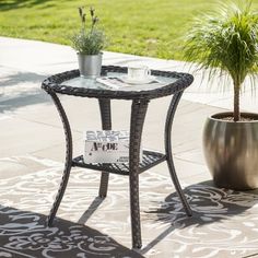 a small table with a potted plant next to it on a patio area rug