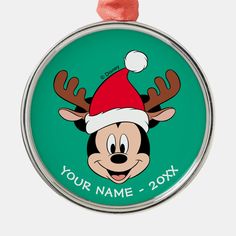 a christmas ornament with a cartoon character wearing a santa hat and reindeer antlers