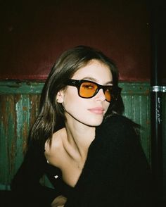 a woman wearing sunglasses is posing for the camera