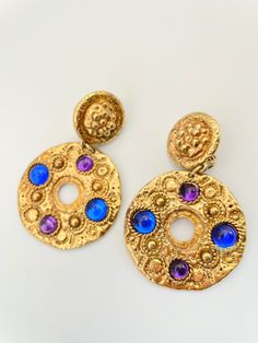 "Gorgeous gold round drop earrings with glass cabochons in, purple and blue. Awesome statement earrings! Nice vintage condition. clip style. approx 3\" long. on the heavier side. Please Note: All of these items are vintage. They have been pre-loved and are not in pristine condition. I try to take photos of any areas of concern. Please ask for more photos if you have any concerns about the condition of a piece. Returns will only be accepted if there is damage in shipping."