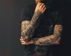 a bearded man with tattoos on his arms