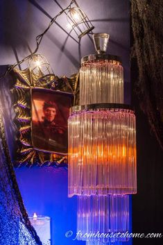 a chandelier hanging from the ceiling in front of a framed photo and other decorations