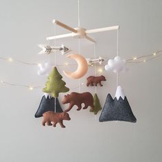 a mobile with bears and trees hanging from it's sides in front of a white wall