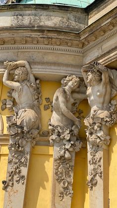 three statues on the side of a building