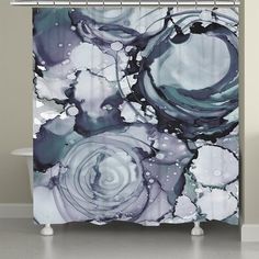 an abstract shower curtain with blue and white paint splattered on the outside, in front of a bathtub