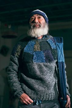 an old man with a beard wearing a sweater