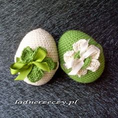 two crocheted baby shoes with green bows and white flowers on the top one