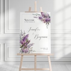 an easel with a wedding welcome card on it in front of a white wall