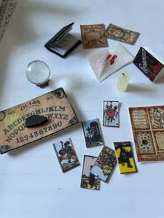 a table topped with lots of different types of cards next to a candle and some candles