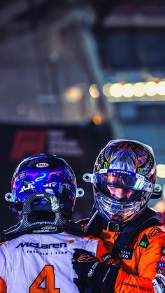 two men in helmets standing next to each other