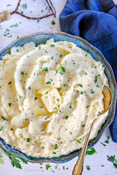 a bowl filled with mashed potatoes on top of a blue and white table cloth