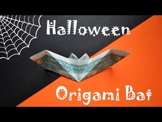 an origami bat with the word halloween written on it and spider web in the background