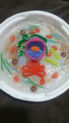 a paper plate that has some plastic items in it on top of black cloth with buttons