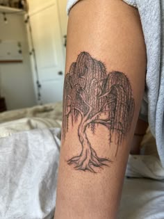 a woman's arm with a tree tattoo on the left side of her leg