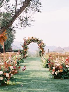 an outdoor ceremony setup with flowers and greenery