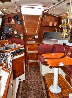 the inside of a boat with wooden tables and booths on it's sides,