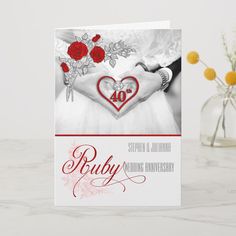 a wedding card with the words forty and two roses on it, in front of a vase filled with flowers