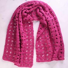 a pink crocheted scarf sitting on top of a white counter