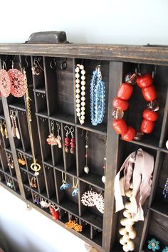 a wooden shelf filled with lots of jewelry