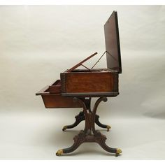 an old piano sitting on top of a wooden stand