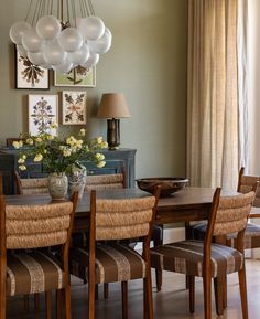 a dining room table with chairs and pictures on the wall above it, in an instagram