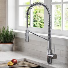 a kitchen sink with a faucet and some fruit on the counter next to it