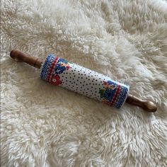 an umbrella laying on top of a white carpet next to a wooden stick with polka dots