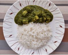 a white plate topped with rice and green sauce