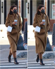 the woman is wearing a face mask while walking down the street with her coffee in hand