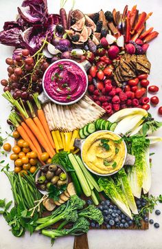 an array of vegetables and fruits arranged in the shape of a circle on a cutting board