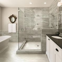 a large bathroom with a walk in shower next to a white bathtub and sink