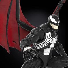 a spider - man action figure is posed in front of a black background with red wings