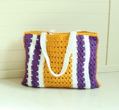 a crocheted bag sitting on top of a white table next to a wall