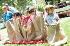 several children are playing with bags in the grass