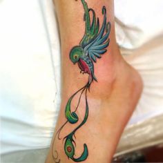 a colorful bird tattoo on the ankle