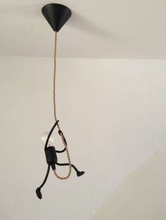 a black light fixture hanging from the ceiling in a room with a chain attached to it