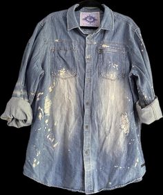 an old blue jean shirt with white spots on the chest and sleeves, worn down