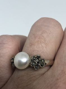 Vintage hand made Genuine Pearl set in 925 Sterling Silver with Marcasite ring Can be re sized for you. My jeweler charges about $10-$15 All rings are shipped in a nice gift box. Check out our over a THOUSAND great reviews Engraving is $4 per letter and is not always perfect depending on the piece. It can take a few days if the jeweler is busy. This is payable to Paypal Judithsltd@gmail.com Antique Hallmarked Pearl Ring As Gift, Classic Gemstone Flower Ring For Gift, Victorian Style Silver Pearl Ring As Gift, Victorian White Pearl Ring Gift, Victorian Style White Pearl Ring For Gift, Victorian Style White Pearl Ring Gift, Antique Round Pearl Ring As Gift, Antique Pearl Ring Gift, Marcasite Ring