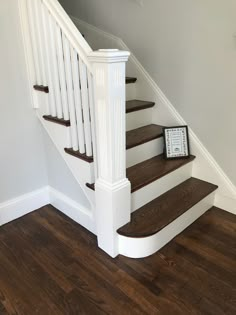 there is a clock sitting on the stairs next to the bannister in this house