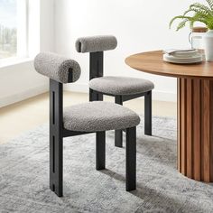 two chairs sitting on top of a rug next to a table with plates and cups