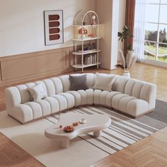 a living room with a large sectional couch and coffee table in the middle, on top of a wooden floor