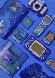 various electronic gadgets are arranged on a blue surface, including cell phones and video game controllers