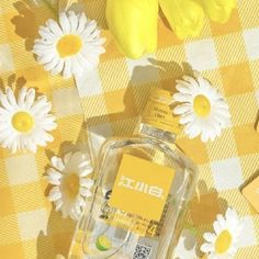 a bottle of perfume sitting on top of a checkered table cloth next to flowers