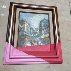 a painting hanging on the side of a wall next to a red framed artwork piece