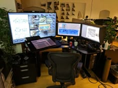 two computer monitors sitting next to each other on top of a wooden desk in an office